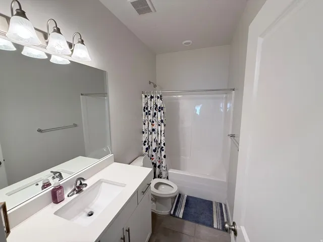 Bathroom featuring a white vanity with an integrated sink, polished chrome faucet, and a large wall-mounted mirror