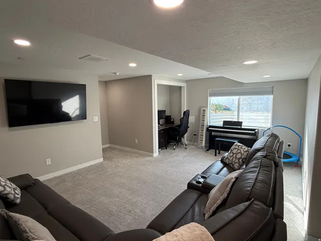 Spacious lower-level area featuring recessed lighting, light gray carpeting, and a large window providing ample natural light