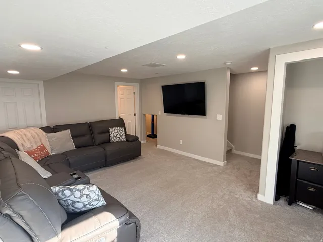 Spacious finished lower level featuring recessed lighting, light-toned carpeting, and neutral wall paint
