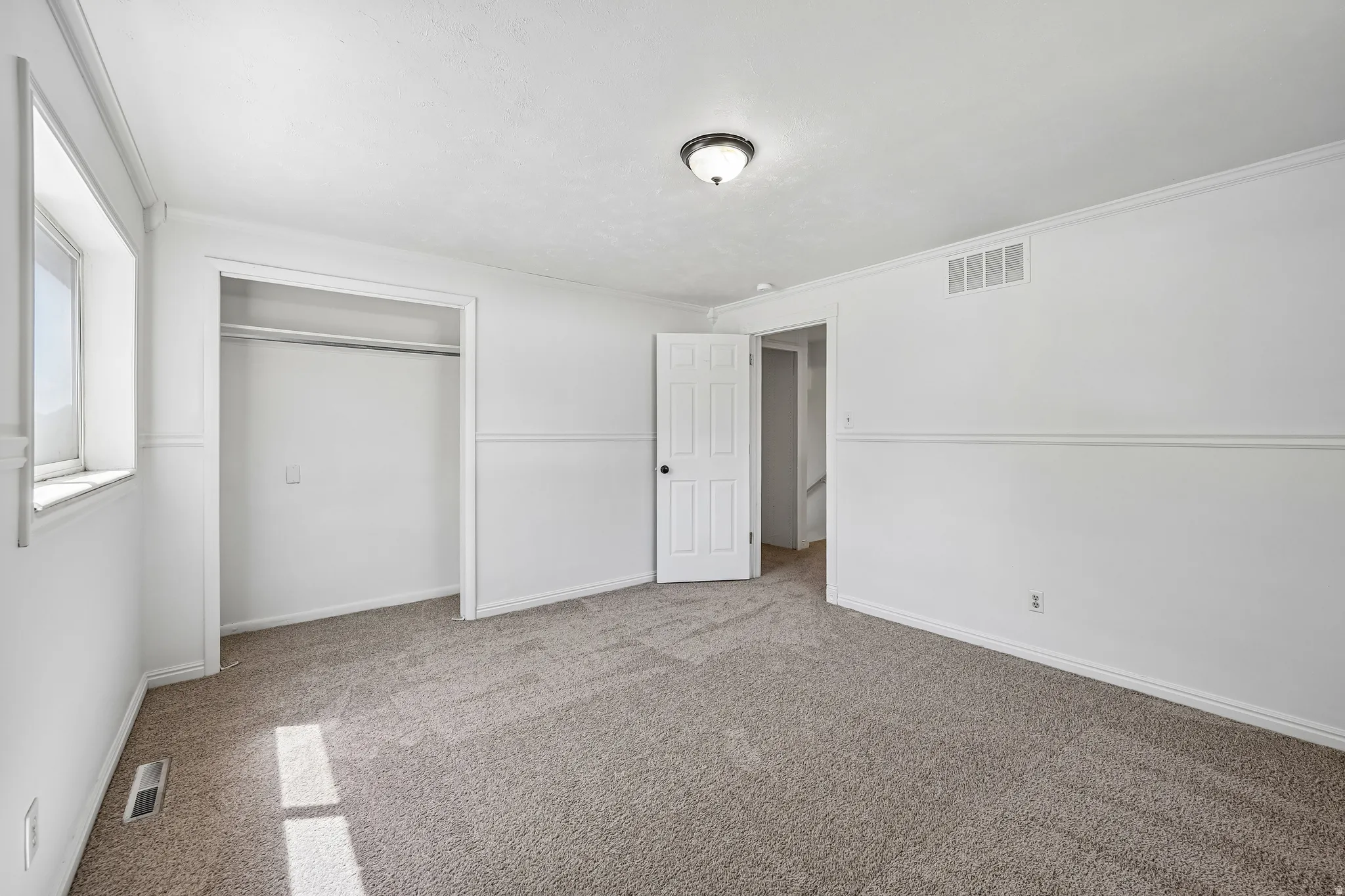 Neutral tone wall-to-wall carpeting throughout