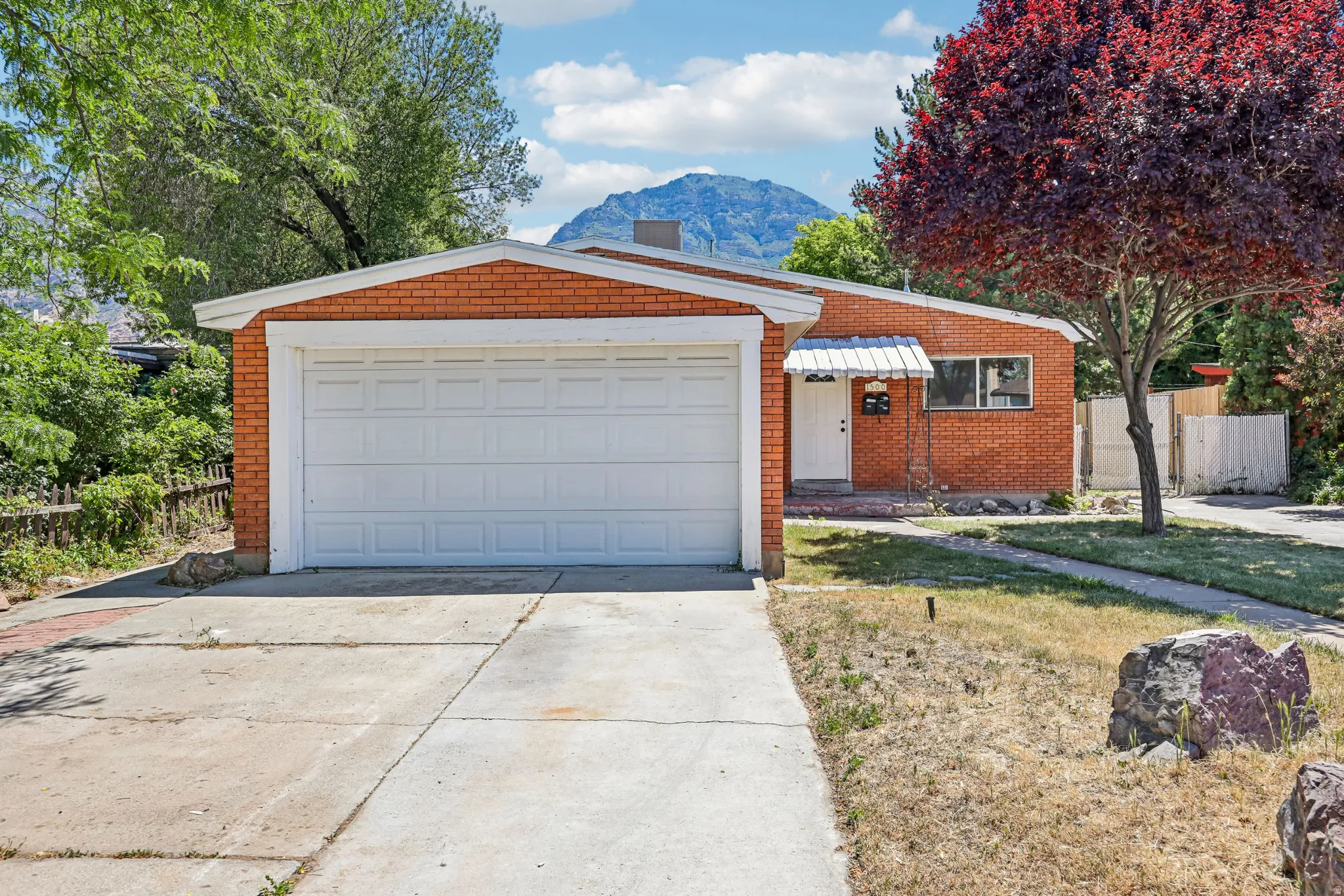 Brick exterior residence featuring an attached garage with a panel door