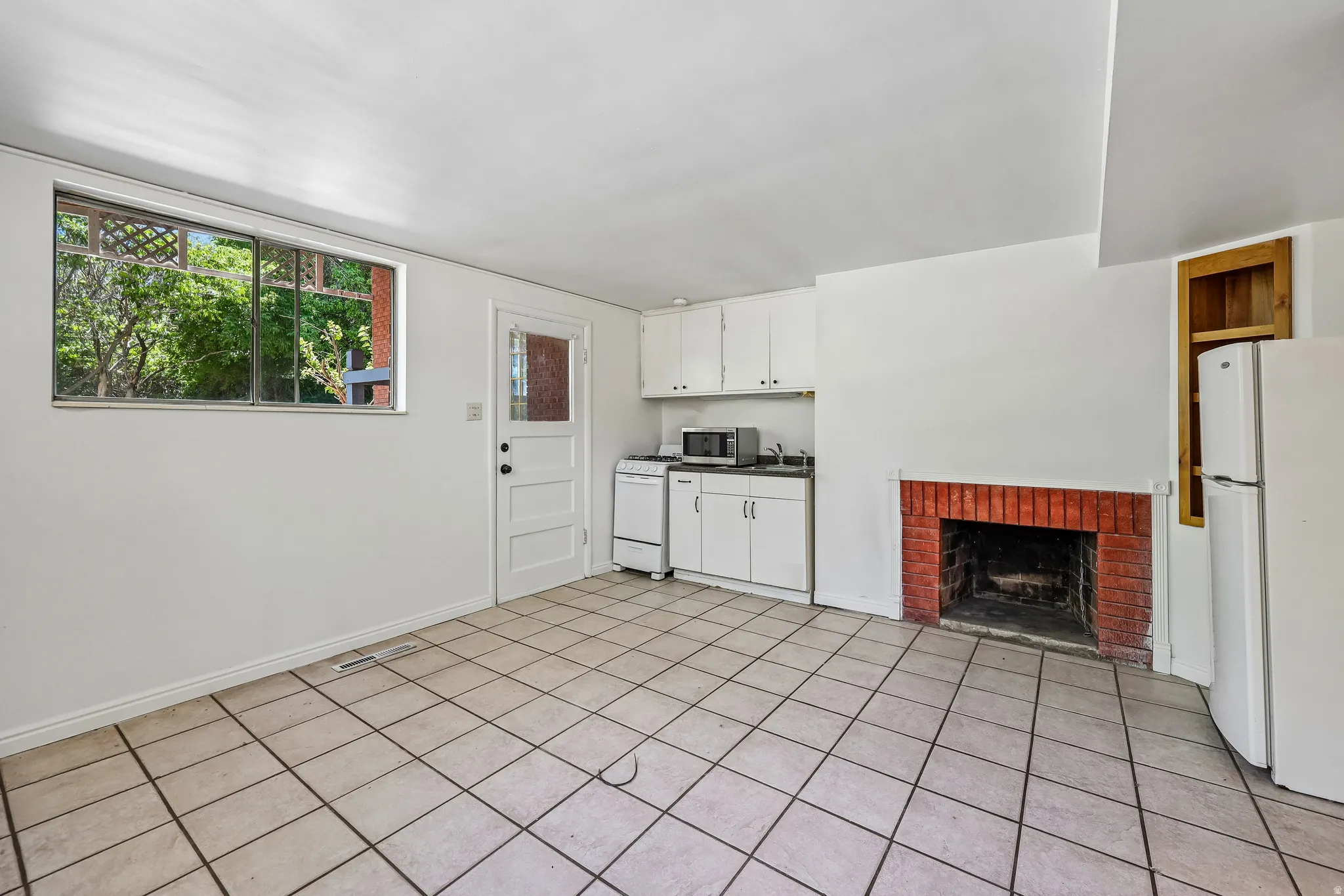Tiled flooring throughout this open space, featuring a brick fireplace