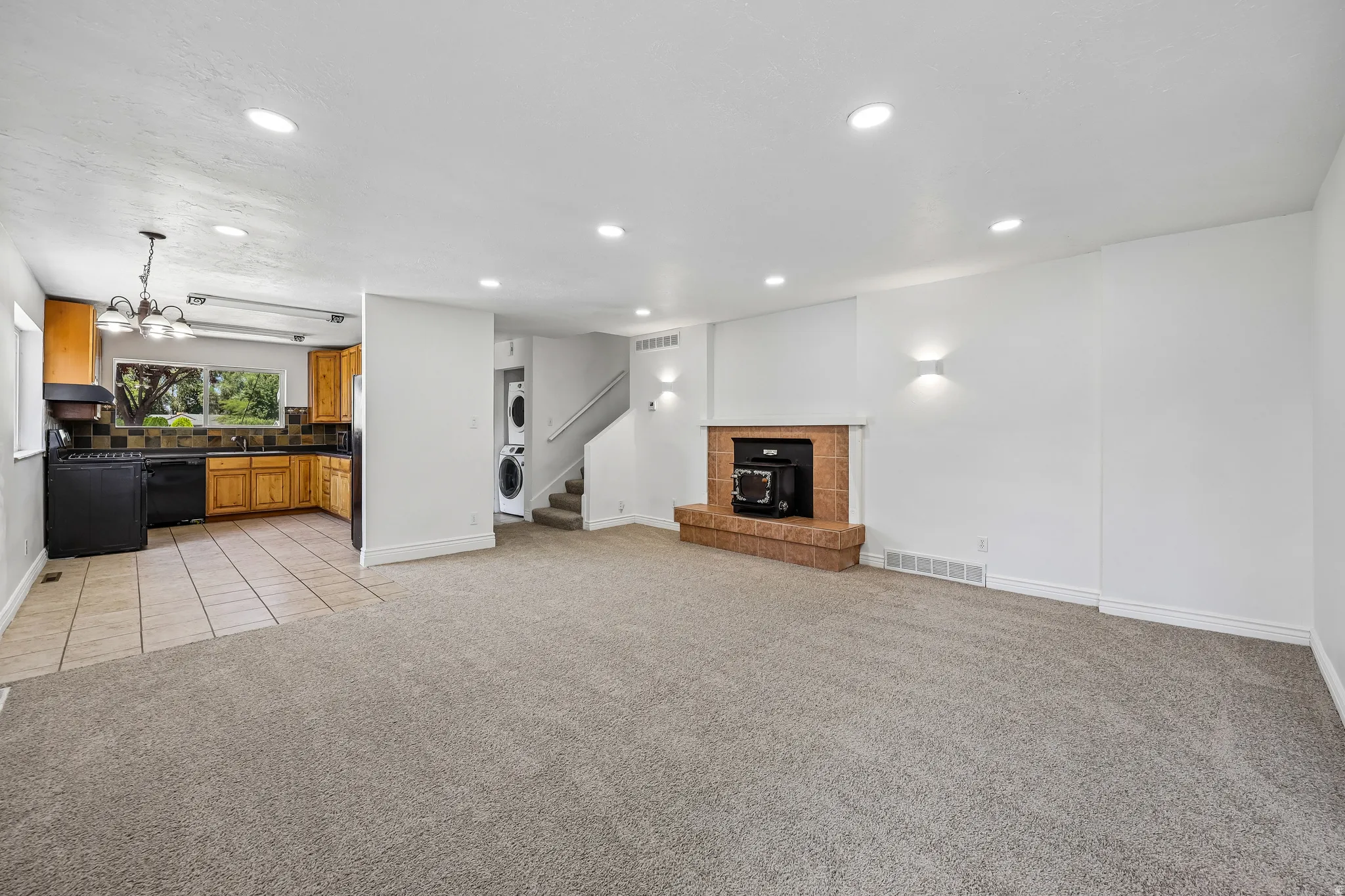 Living space featuring carpet flooring, recessed lighting, and a brick-finish fireplace