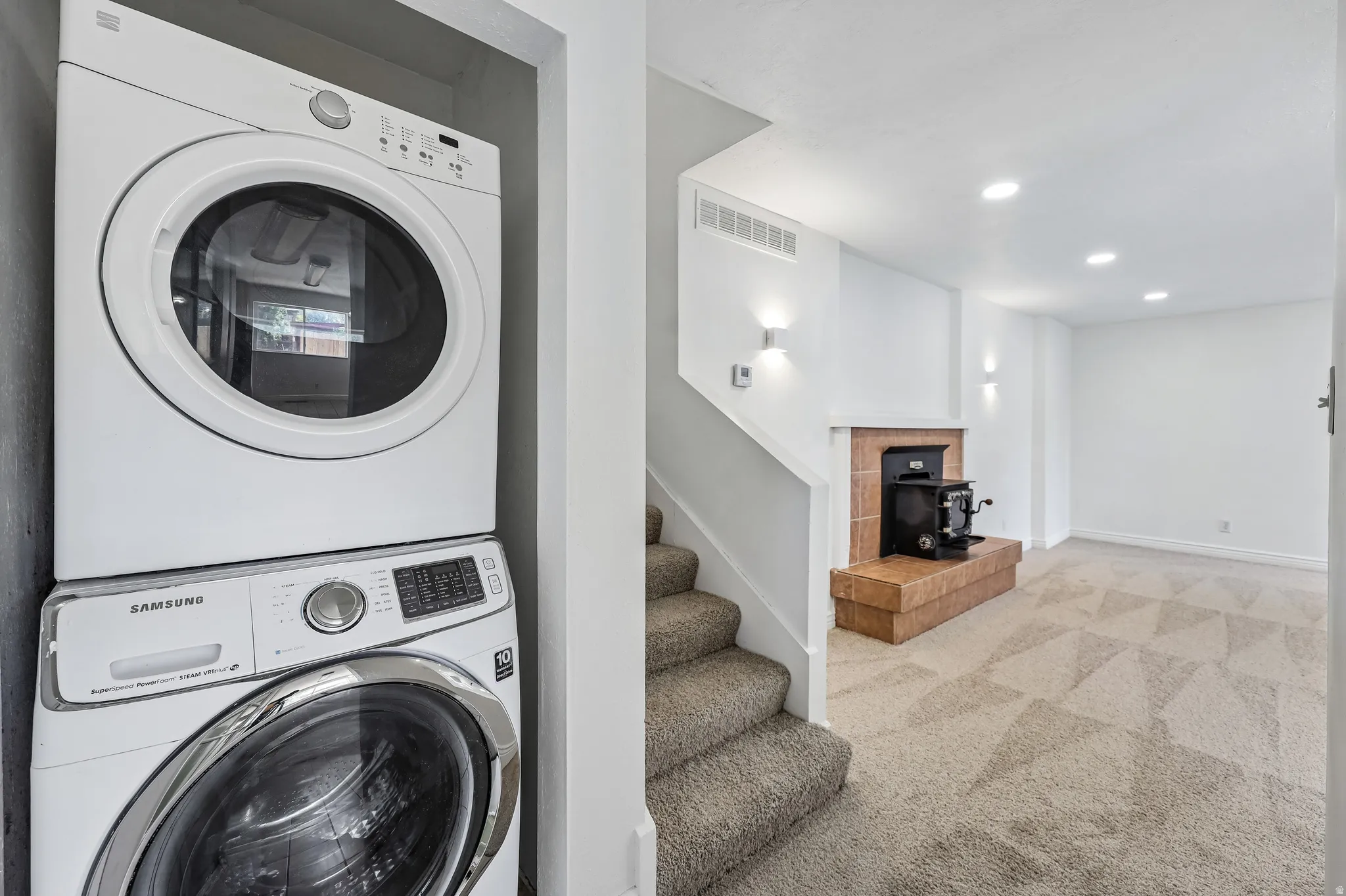 Integrated laundry area featuring a stacked washer and dryer