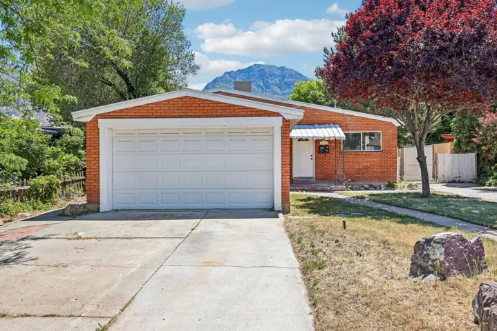 Brick exterior residence featuring an attached garage with a panel door