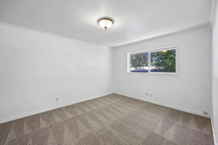 Bright interior space featuring light-colored walls and patterned carpeting