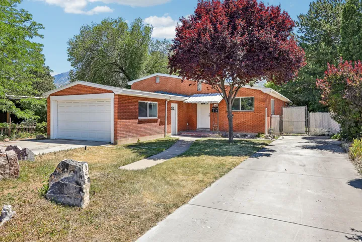 Brick exterior residence featuring an attached garage with a panel door