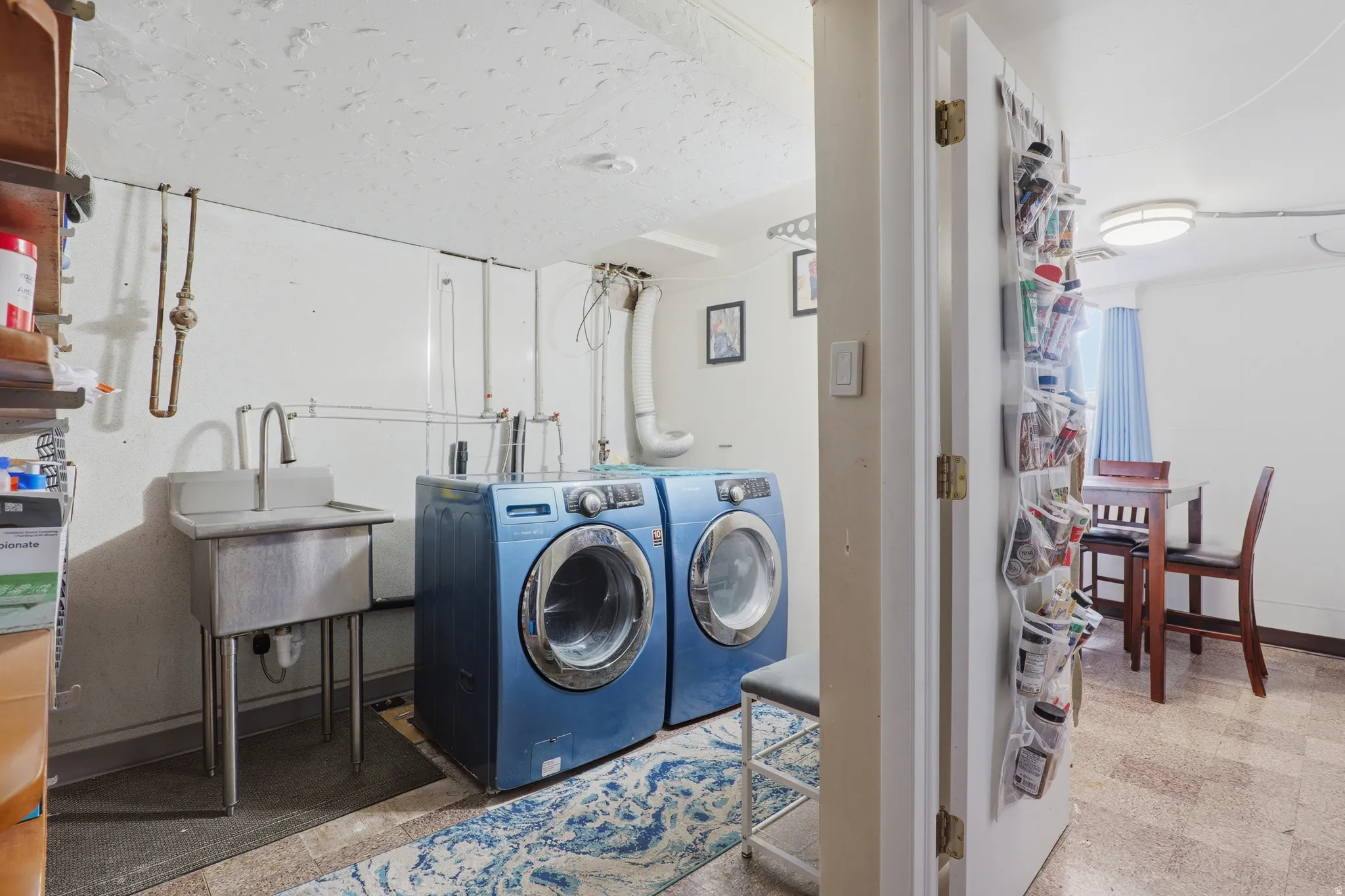 Dedicated laundry area featuring a utility sink and durable flooring