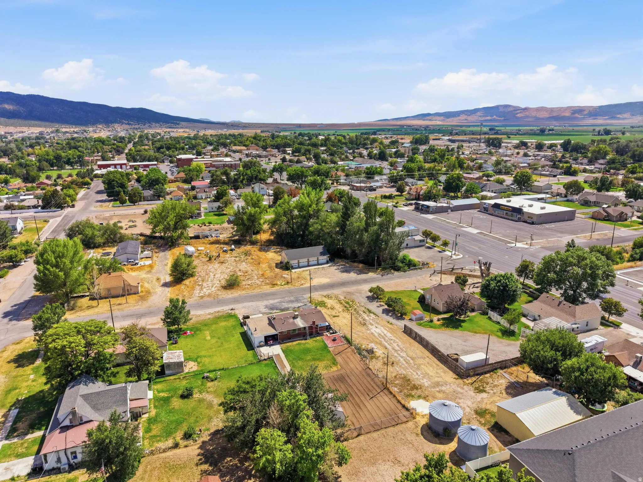 Expansive aerial view showcasing residential properties, commercial buildings, and agricultural fields