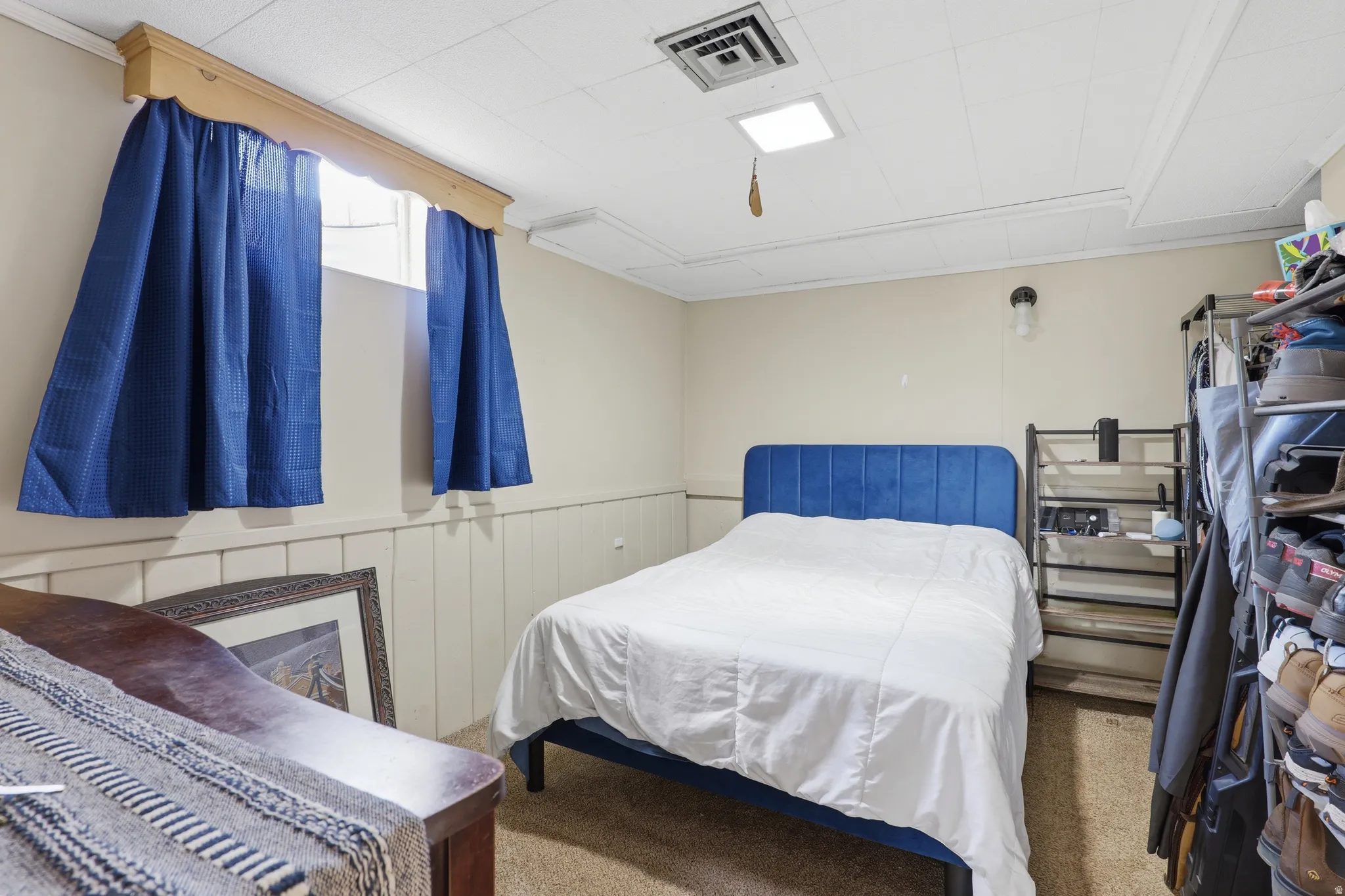 Carpeted room featuring a drop ceiling with recessed lighting and a ventilation grate