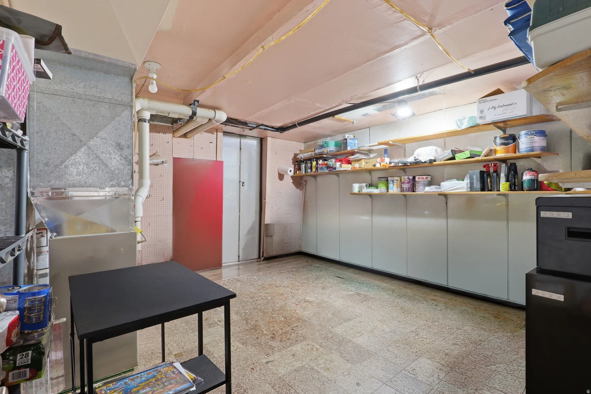 Utility space featuring a concrete slab floor and exposed ceiling beams