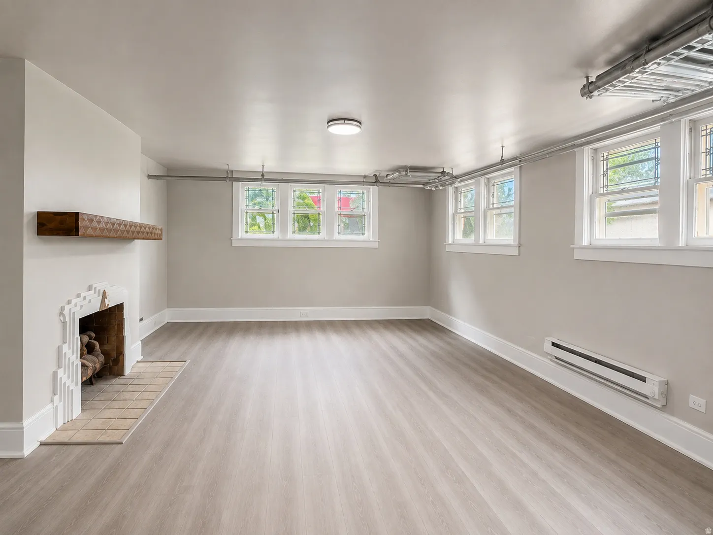 Light wood-finish flooring with a decorative fireplace and wood mantel