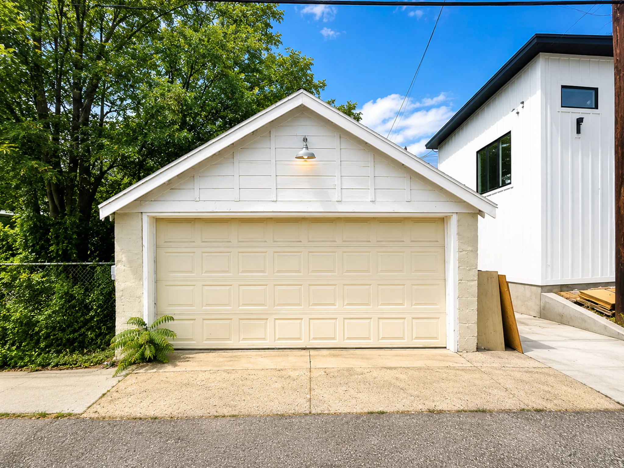 Detached garage with a paneled door and gabled roofline