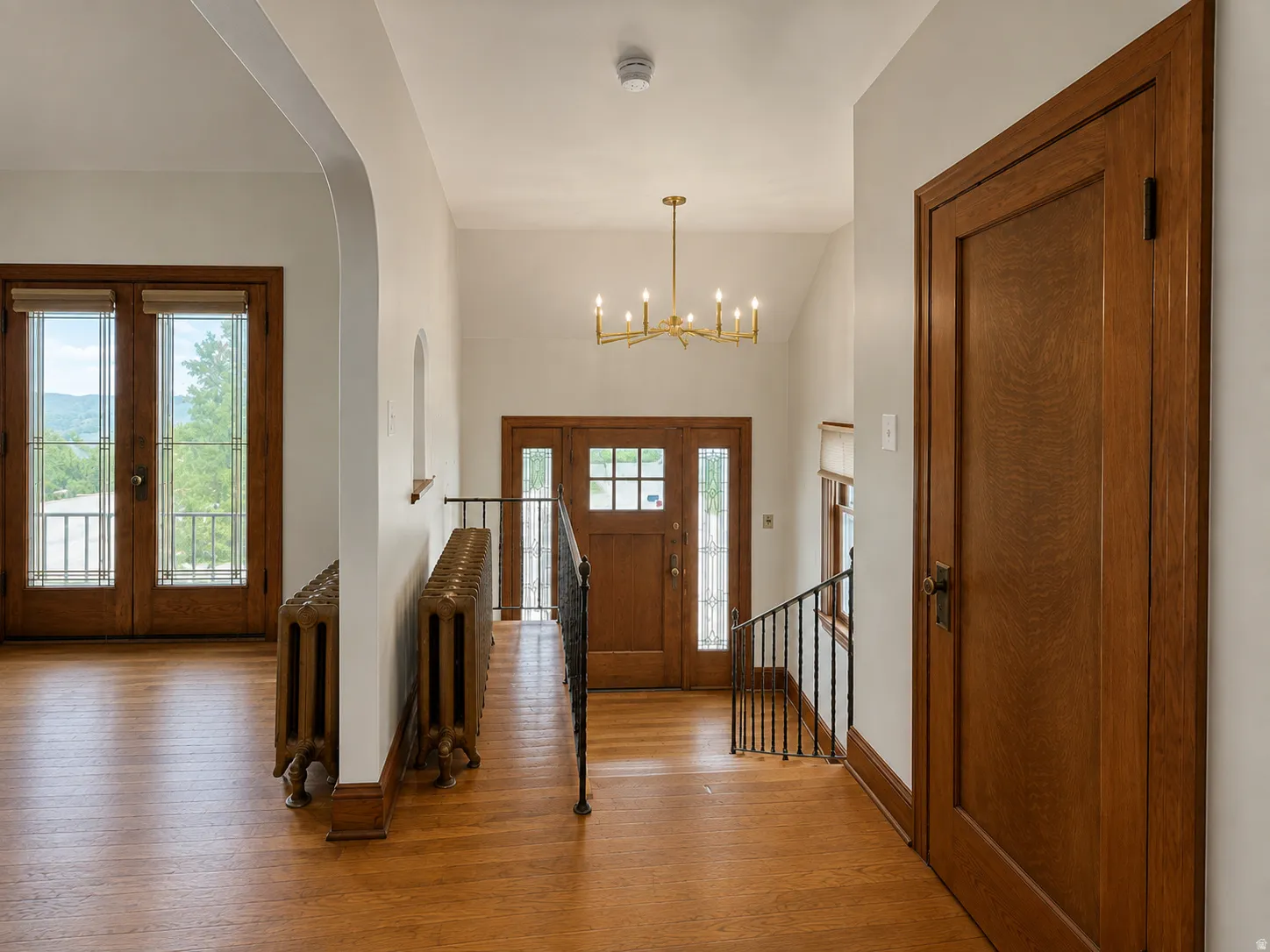 Wood-finish flooring throughout, featuring a natural wood front door with glass panels