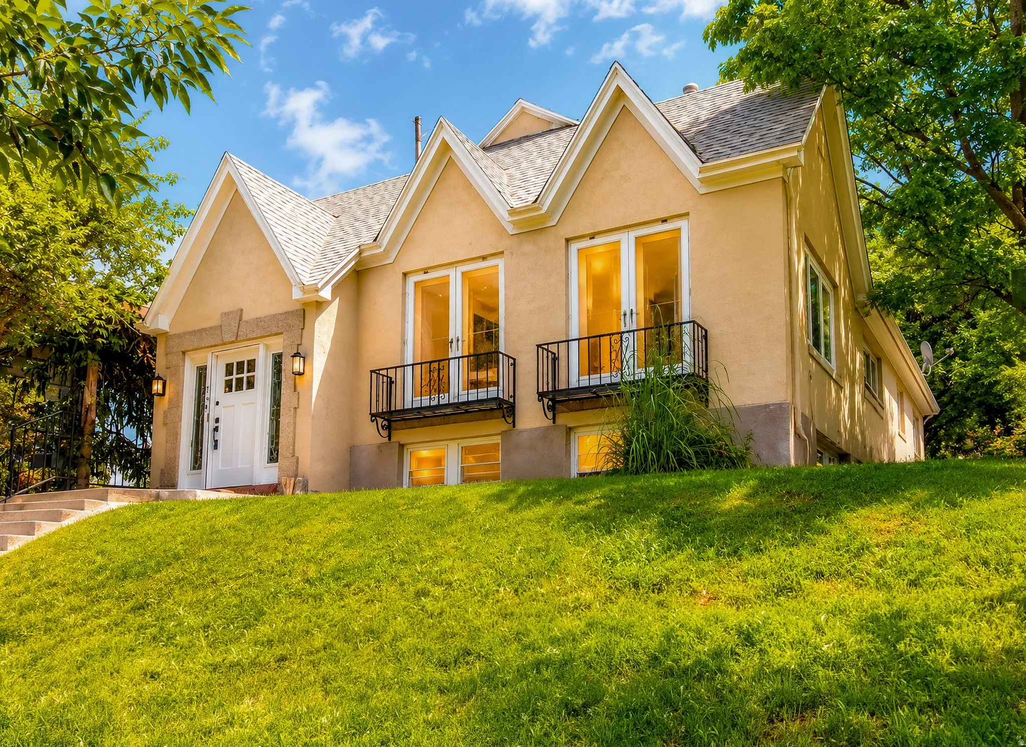 Stucco exterior with multiple gables and a multi-pane front door