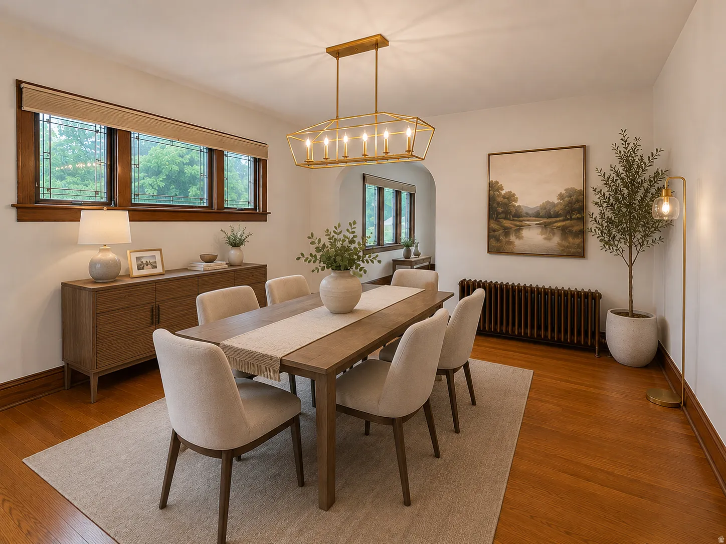 Hardwood flooring, arched doorway, decorative leaded glass windows, and a warm bronze chandelier