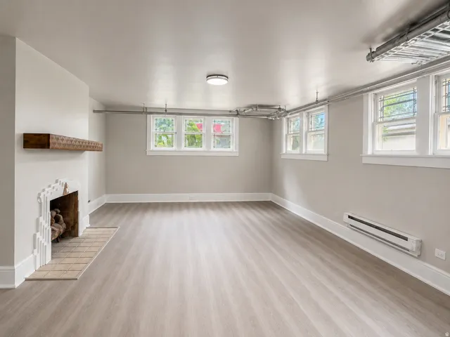 Light wood-finish flooring with a decorative fireplace and wood mantel