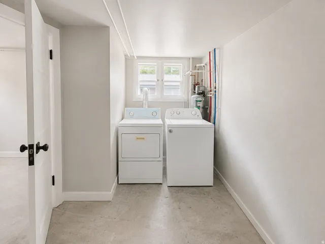 Dedicated laundry area with concrete flooring, a single window, and visible utility connections