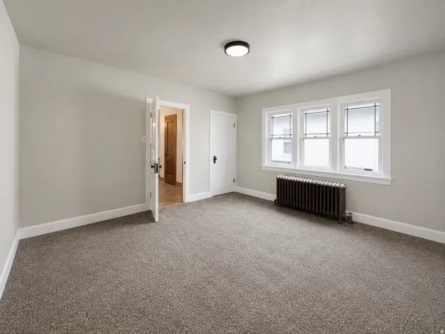 Neutral wall paint, carpet flooring, triple pane windows, and a flush mount ceiling light