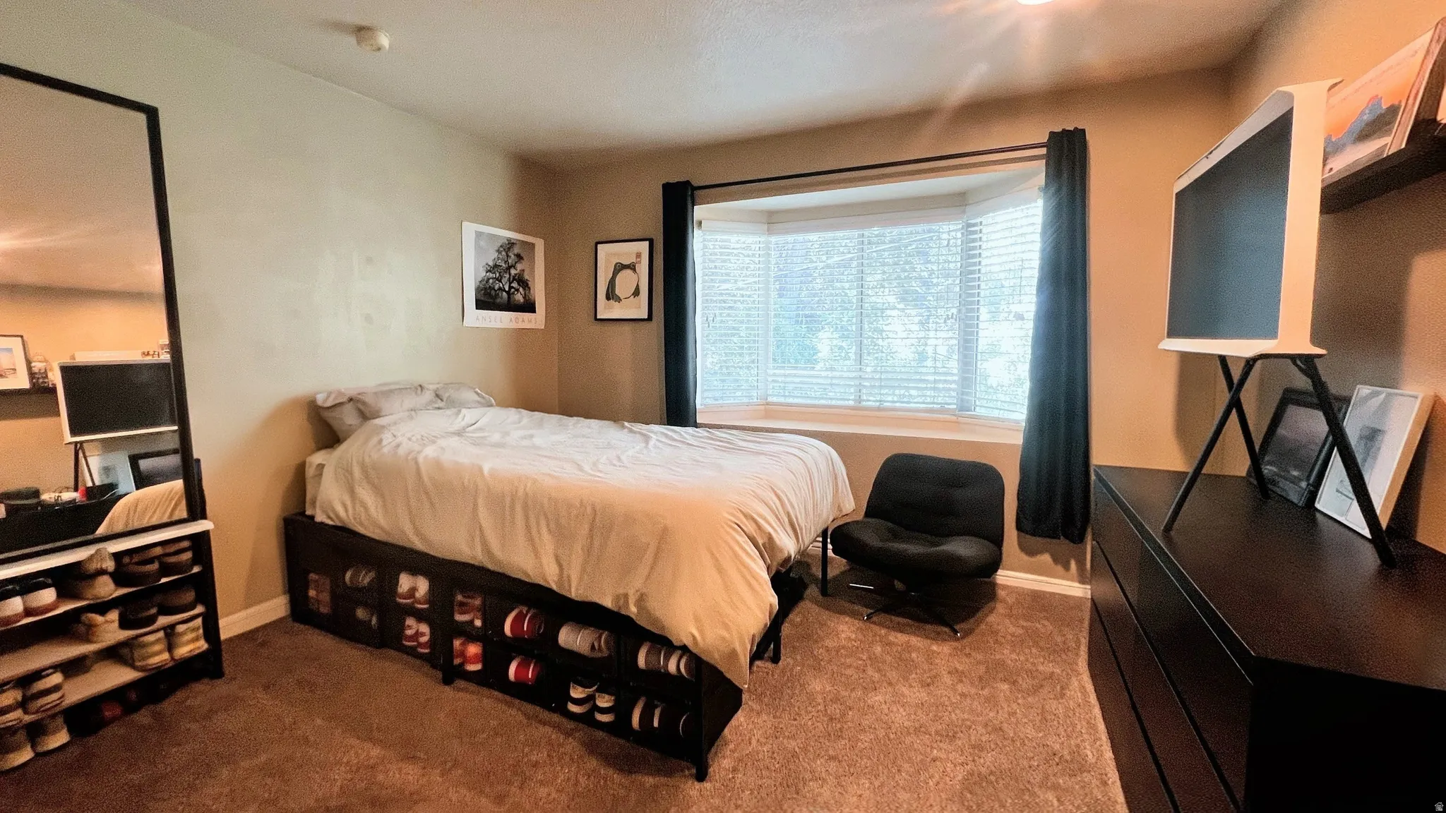 Primary Bedroom featuring a bay window with blinds, carpet flooring, and a neutral wall color