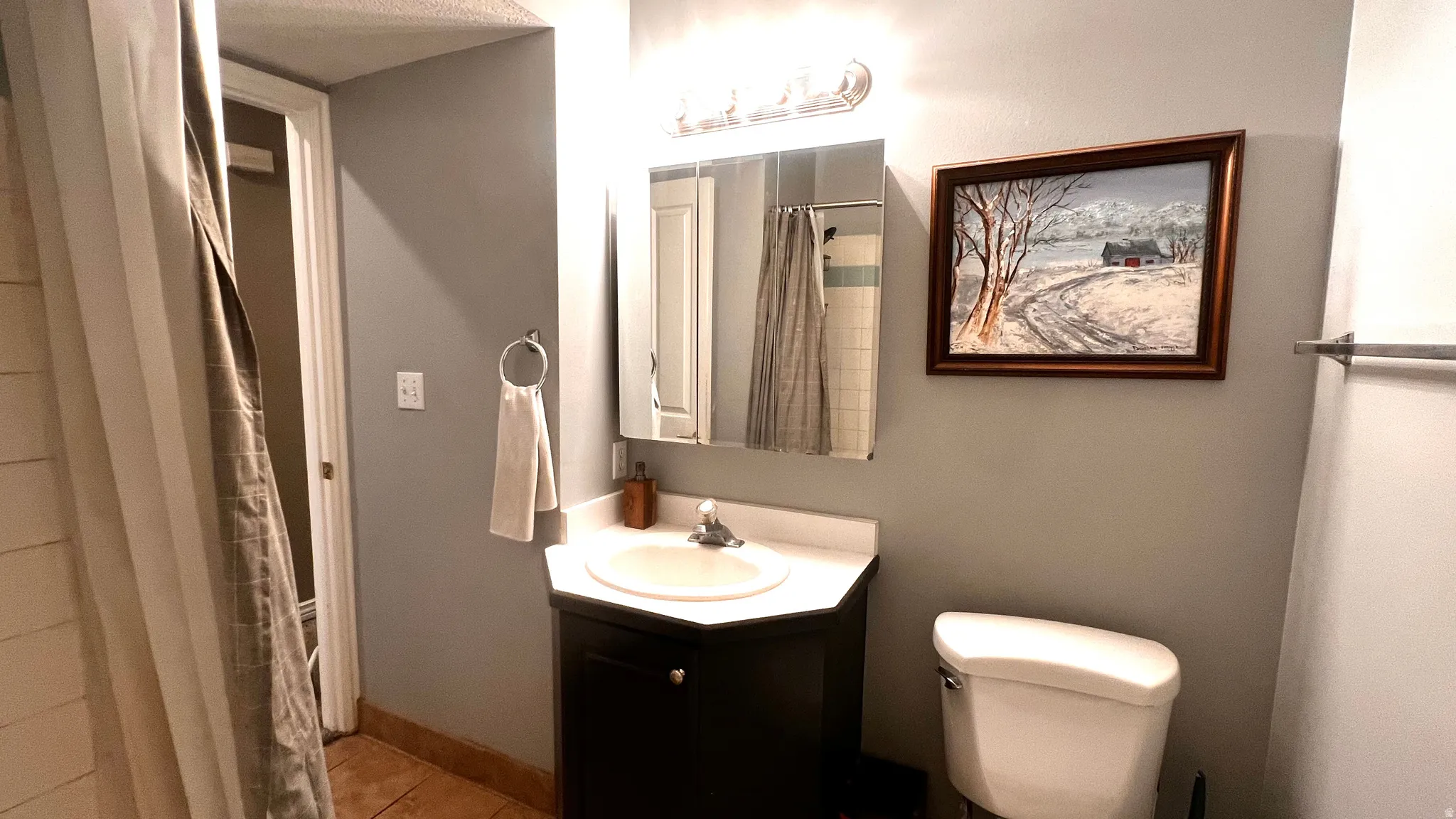 Bathroom vanity with an integrated sink, dark wood-finish cabinetry, and a chrome faucet