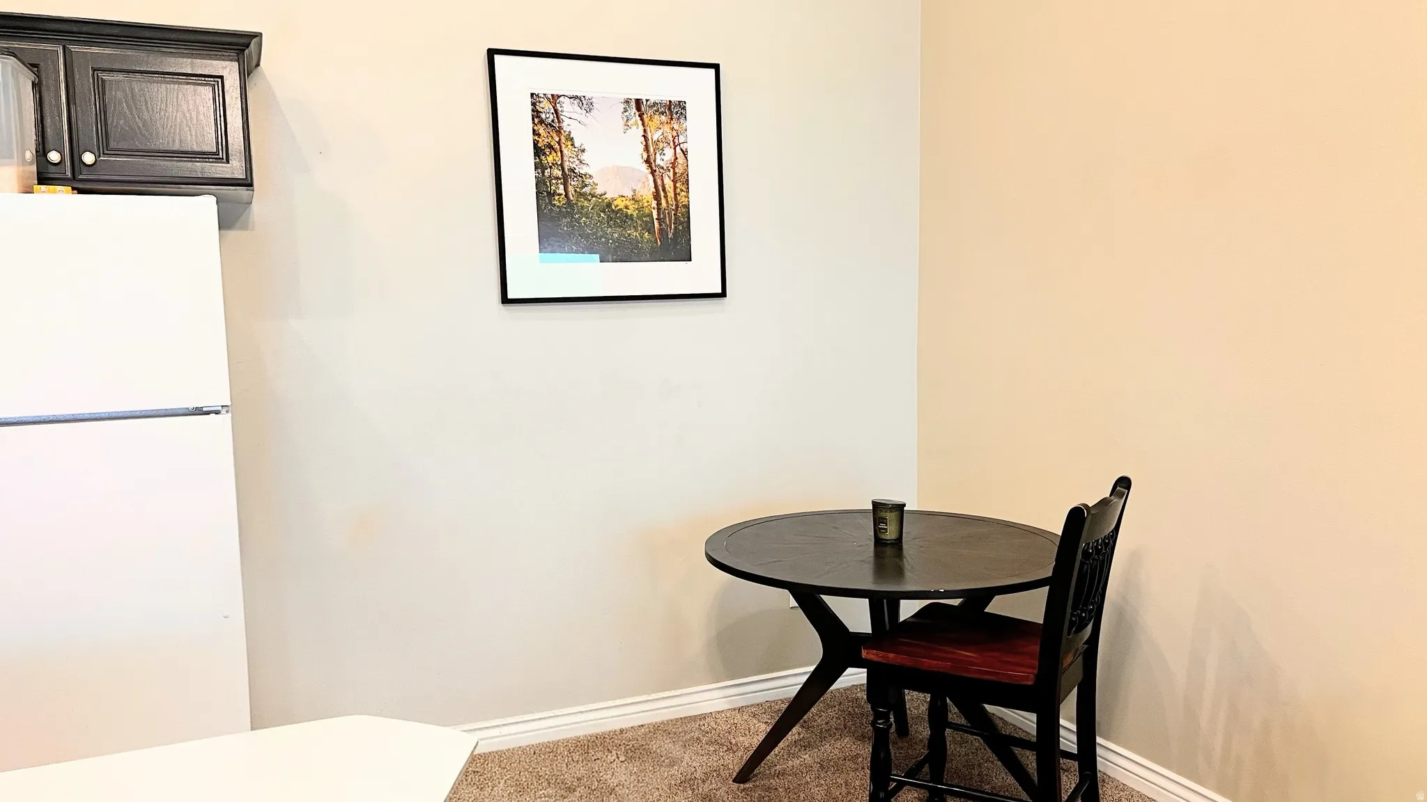 Kitchenette featuring white refrigerator, dark wood cabinetry, and neutral wall paint