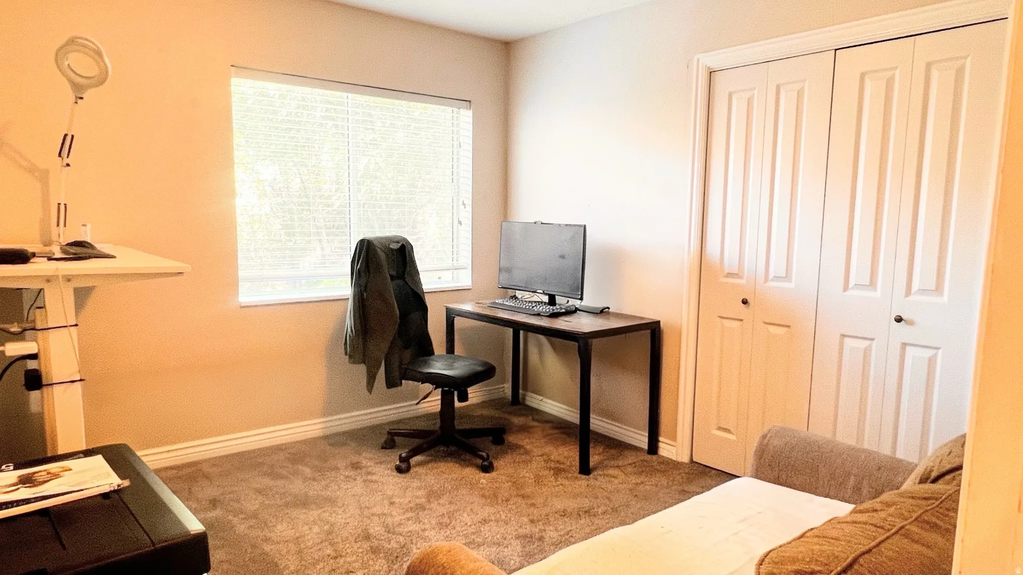 Room featuring a window with horizontal blinds, neutral wall paint, and carpeted flooring