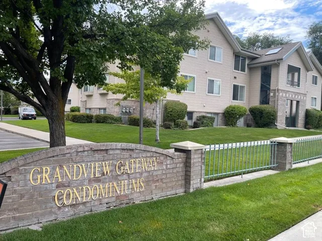"Grandview Gateway Condominiums" signage featuring brick and stone accents, complemented by a metal fence and manicured lawn