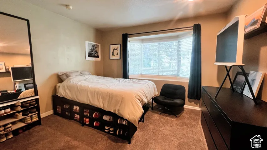 Primary Bedroom featuring a bay window with blinds, carpet flooring, and a neutral wall color