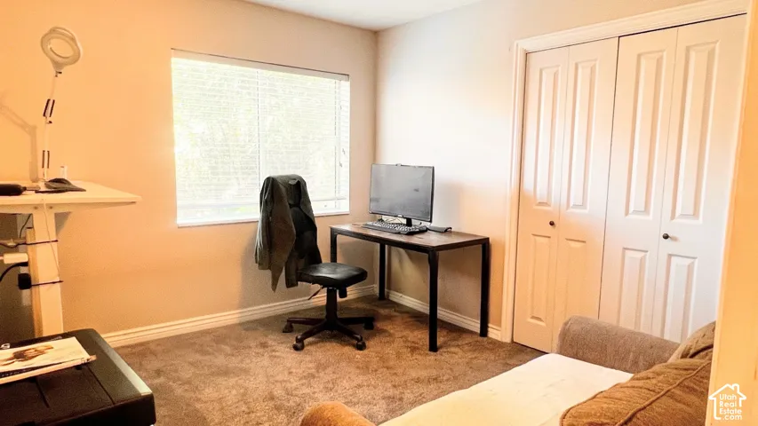 Room featuring a window with horizontal blinds, neutral wall paint, and carpeted flooring
