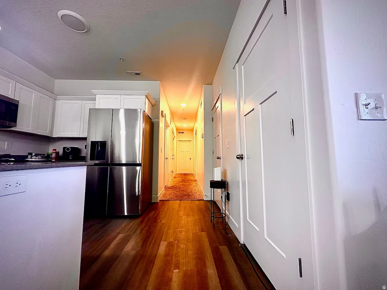 Kitchen area featuring white cabinetry, stainless steel appliances, and a dark countertop