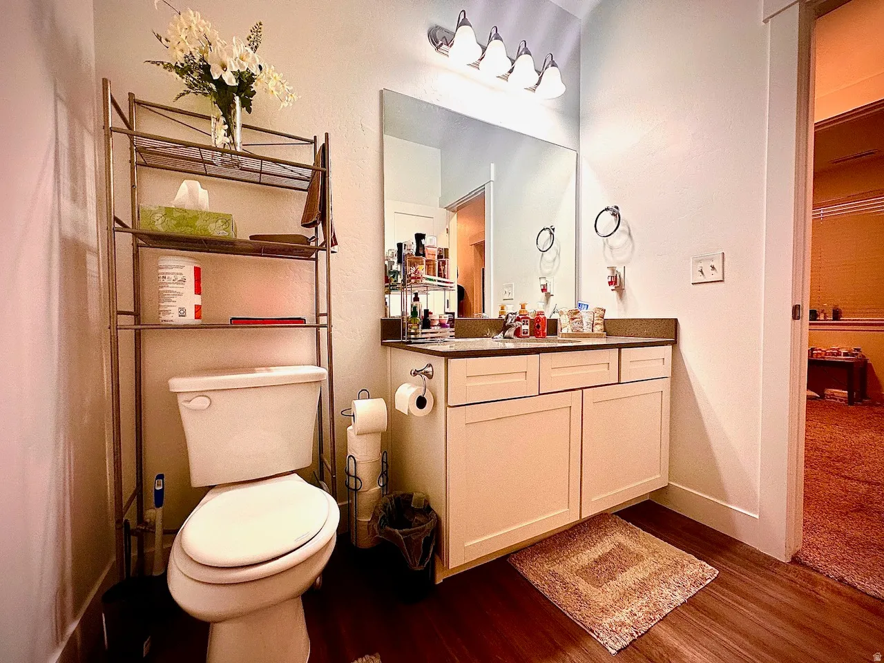 Bathroom featuring a single vanity with light cabinetry, a countertop, and a large mirror