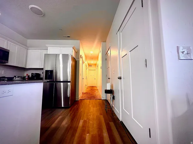 Kitchen area featuring white cabinetry, stainless steel appliances, and a dark countertop