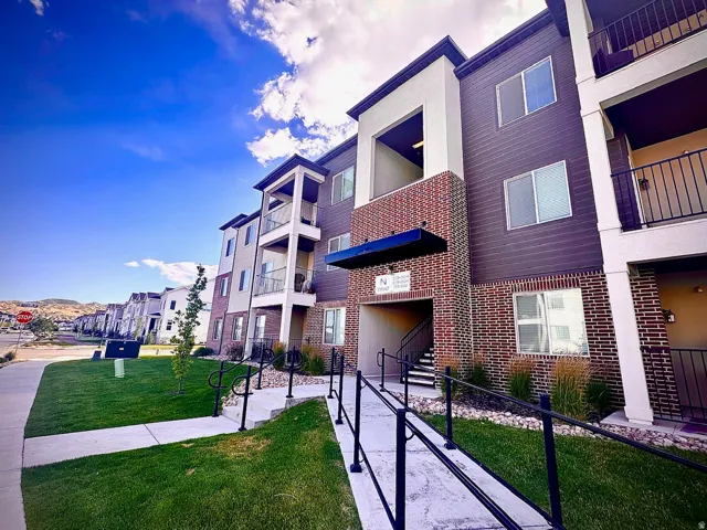 Multi-story building featuring brick, dark siding, and light-colored panels