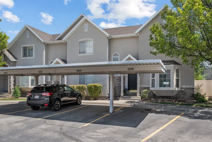 Carport parking with an exterior featuring stucco siding and stone accents