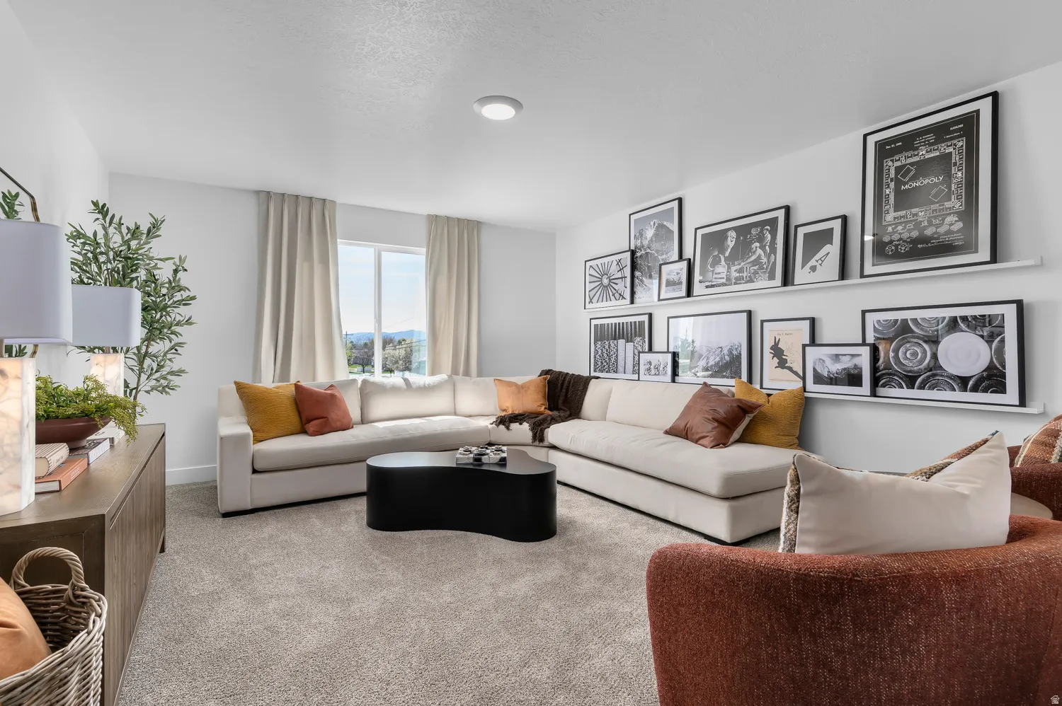 Spacious living area featuring neutral carpeting and a large window with natural light
