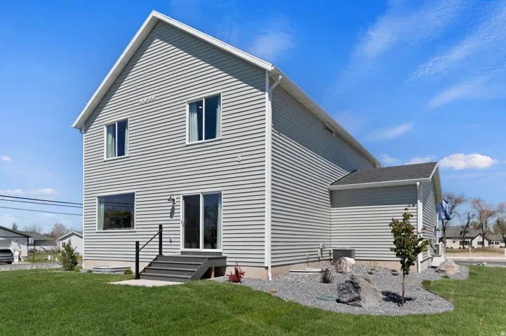 Exterior features gray horizontal siding, a gabled roofline, and white trim