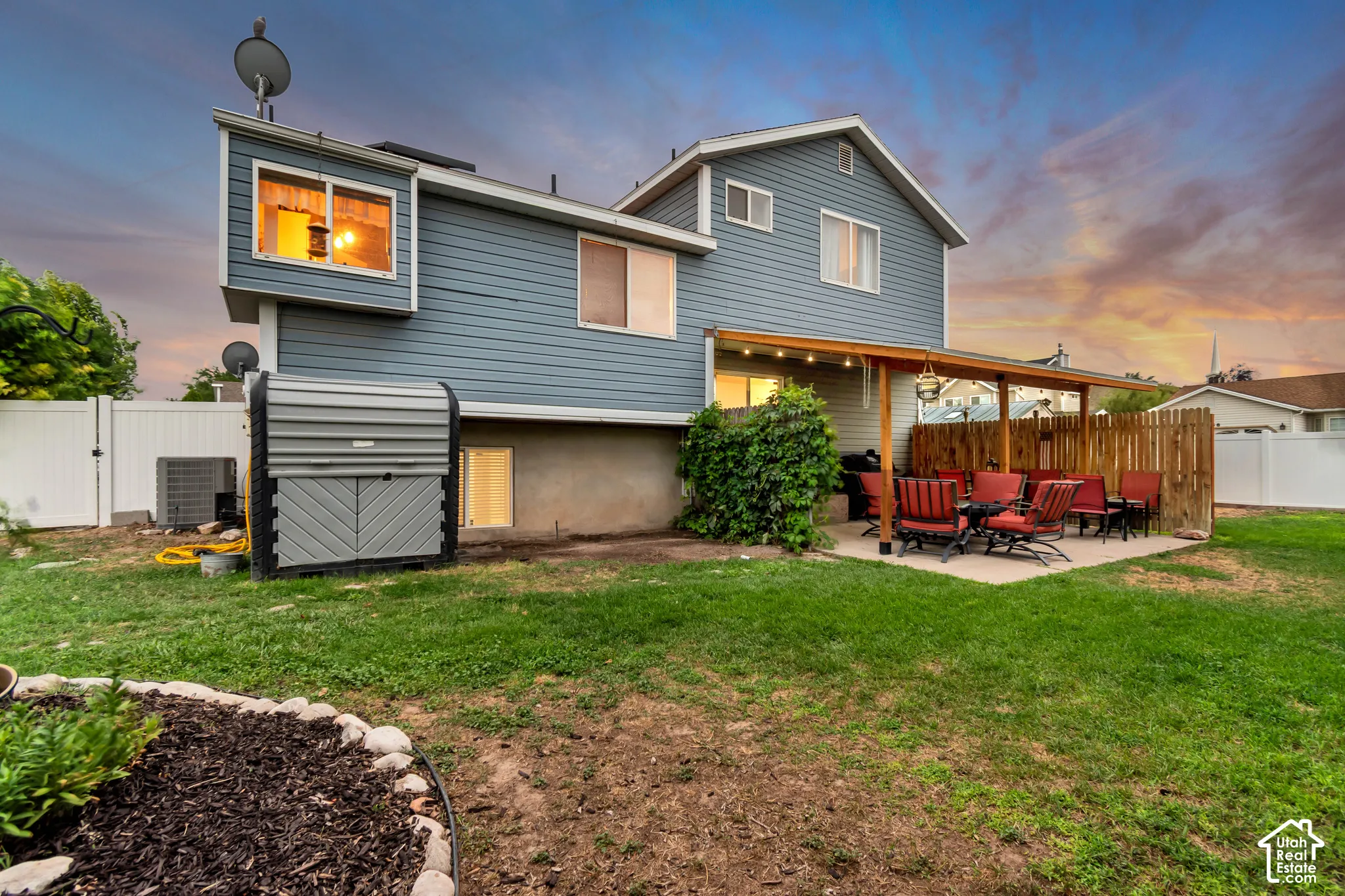 Expansive backyard featuring a covered patio, privacy fence, mature landscaping, and a well-maintained lawn