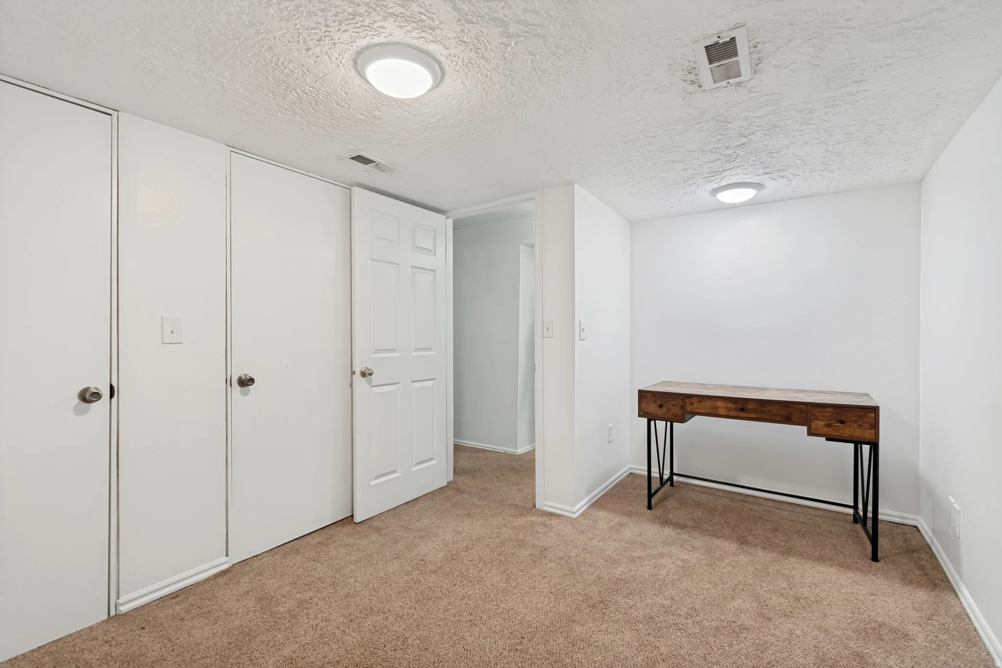 White walls and textured ceiling with recessed lighting