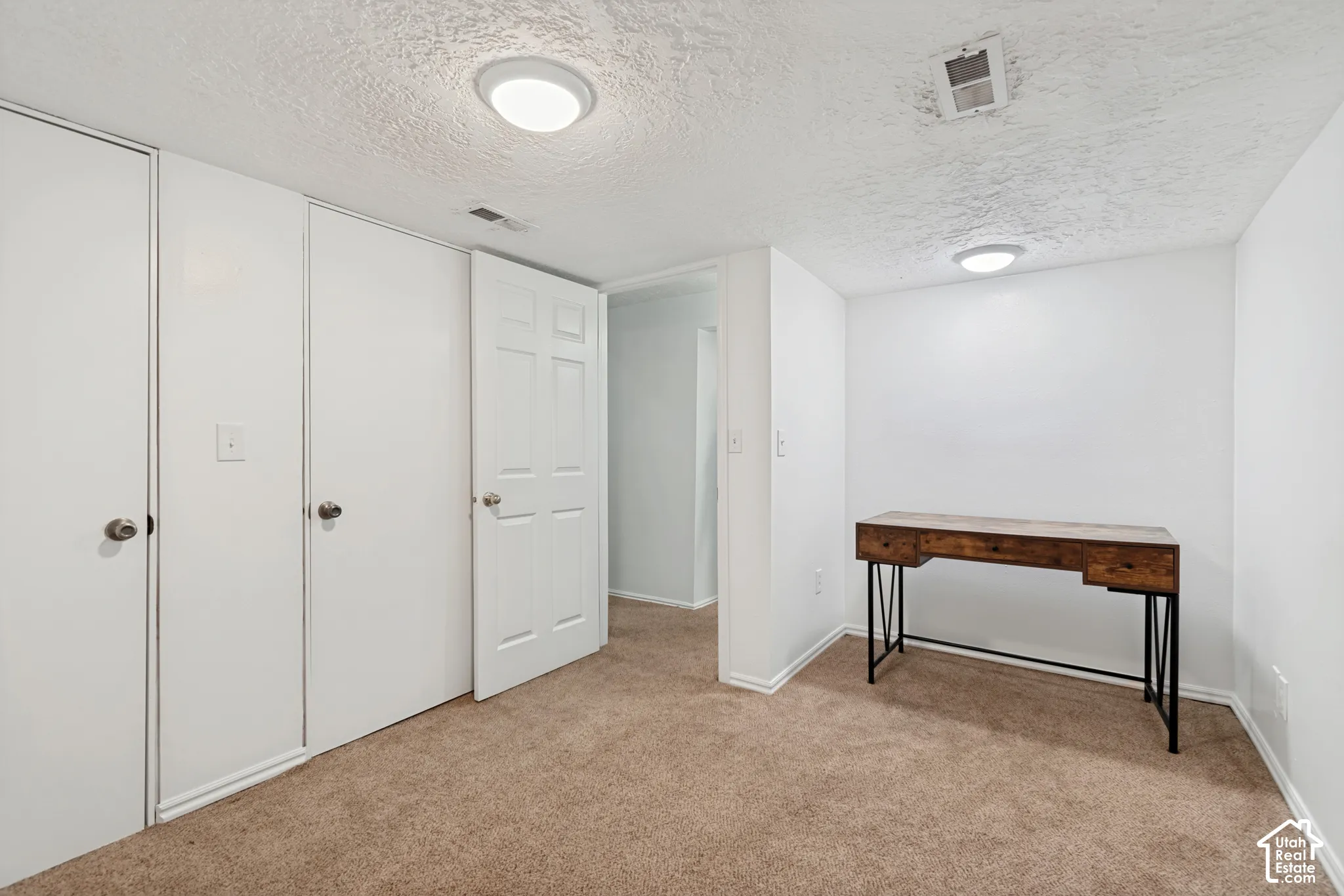 White walls and textured ceiling with recessed lighting