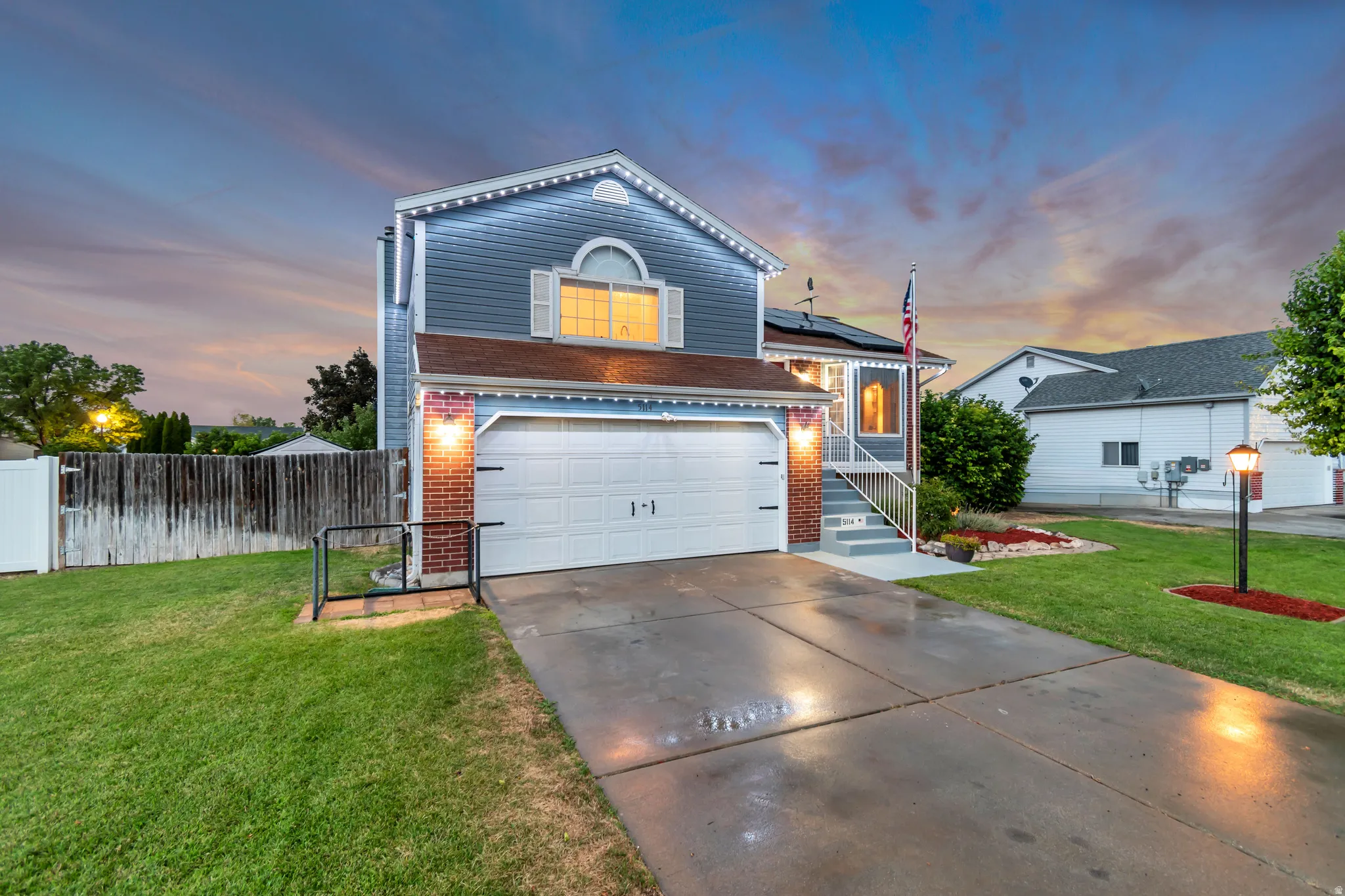 Two-story residence featuring light blue siding with white trim accents and a two-car garage