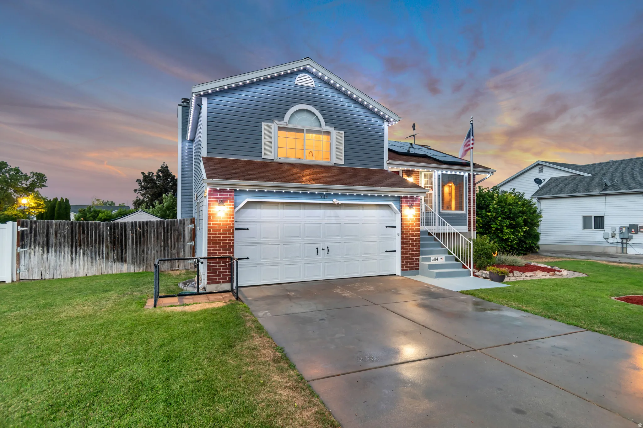 Two-story residence featuring blue siding, a two-car garage, and a concrete driveway