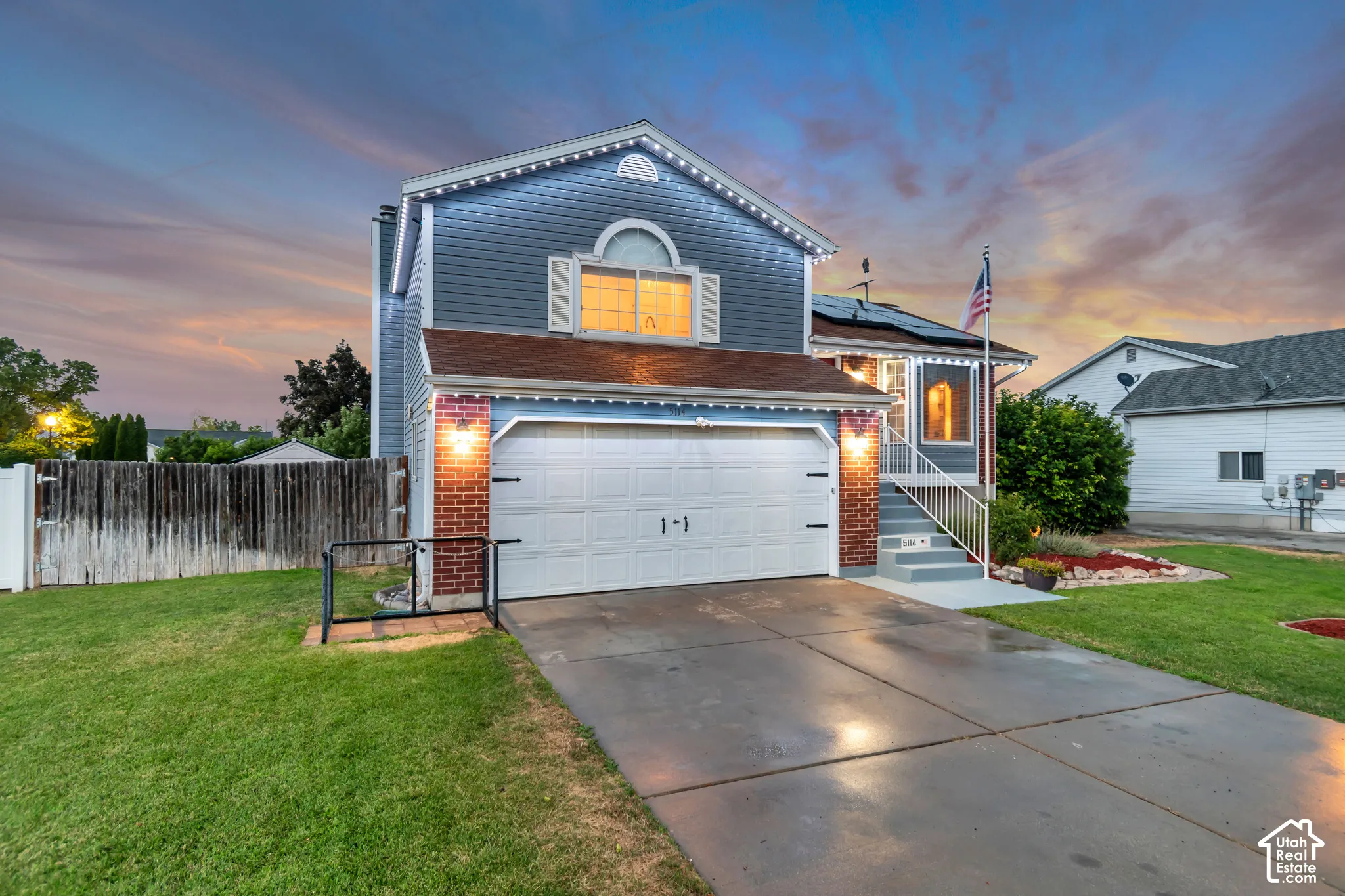 Two-story residence featuring blue siding, a two-car garage, and a concrete driveway