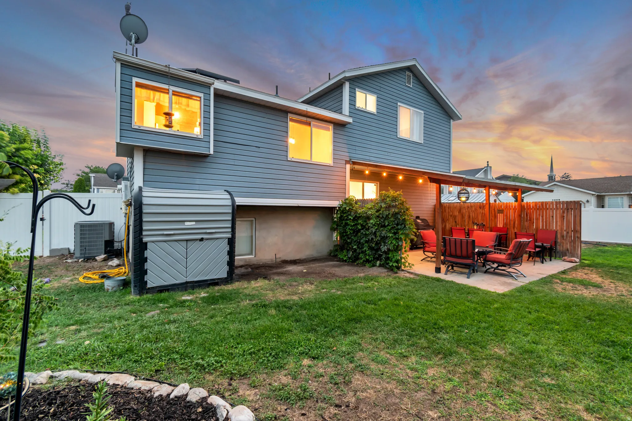 Expansive rear exterior featuring gray siding and a concrete patio