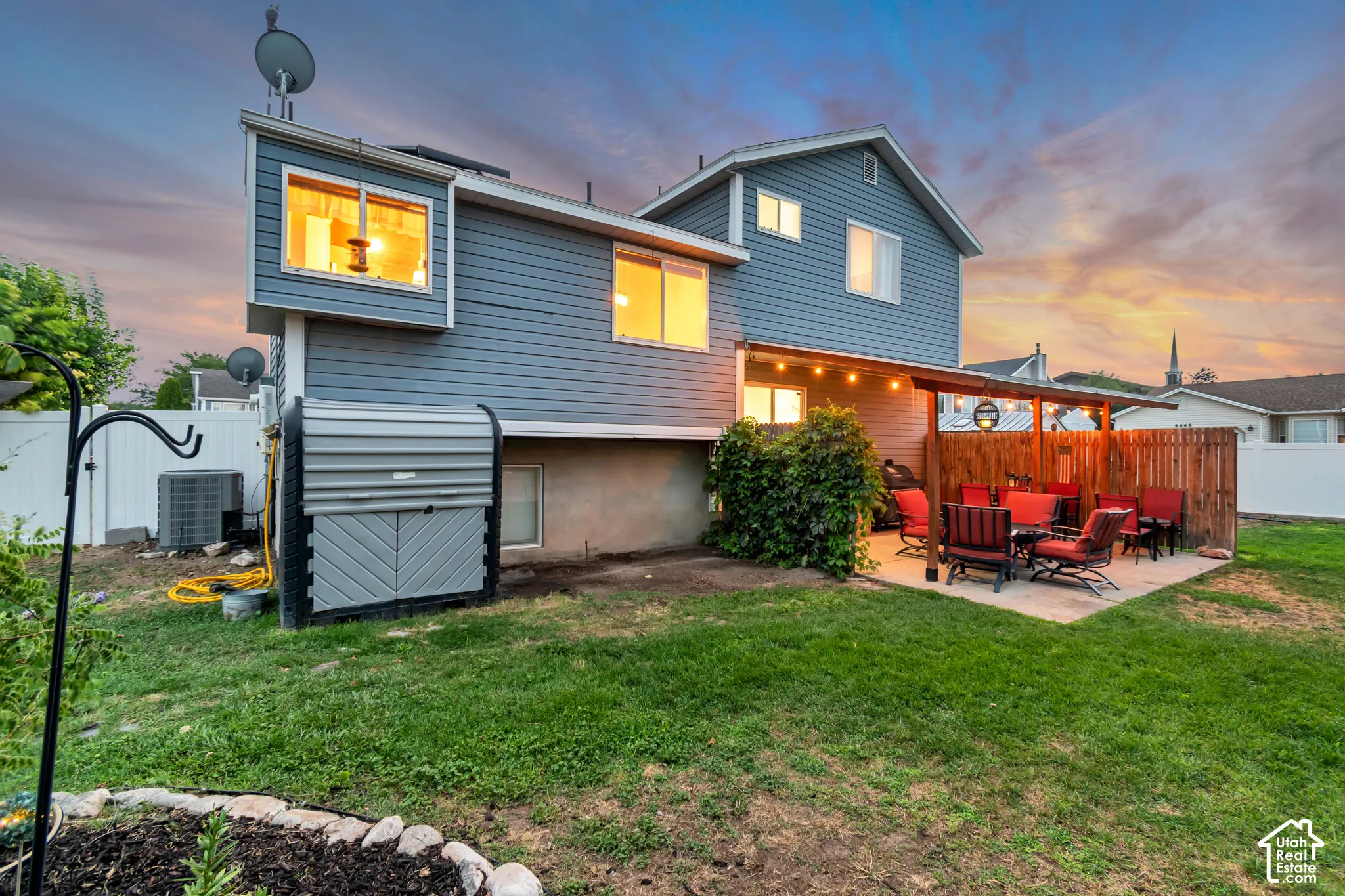 Expansive rear exterior featuring gray siding and a concrete patio