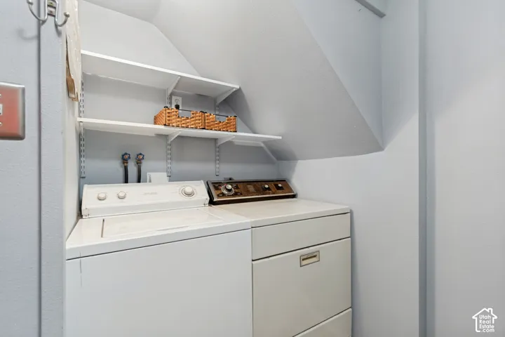 Dedicated laundry area featuring a white top-load washing machine and a white dryer