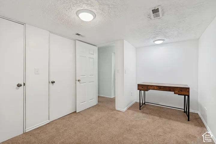 White walls and textured ceiling with recessed lighting
