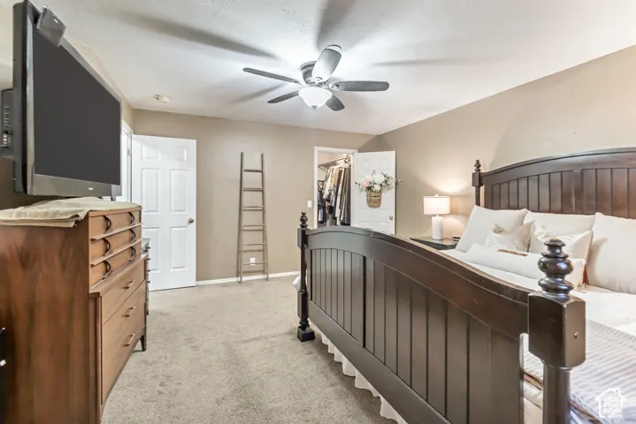 Carpeted bedroom featuring a ceiling fan, neutral wall tones, and a closet with bifold doors