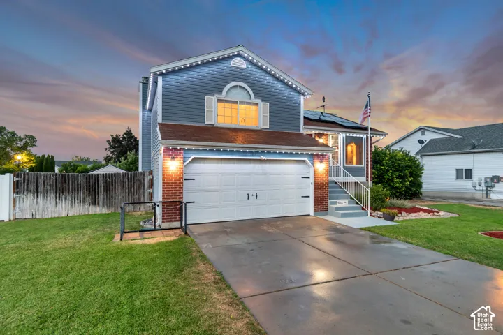 Two-story residence featuring blue siding, a two-car garage, and a concrete driveway