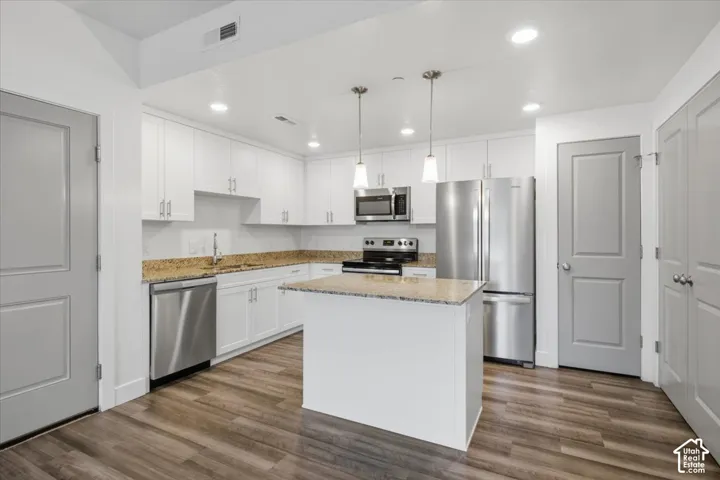 Contemporary kitchen featuring white cabinetry, granite countertops, and stainless steel appliances